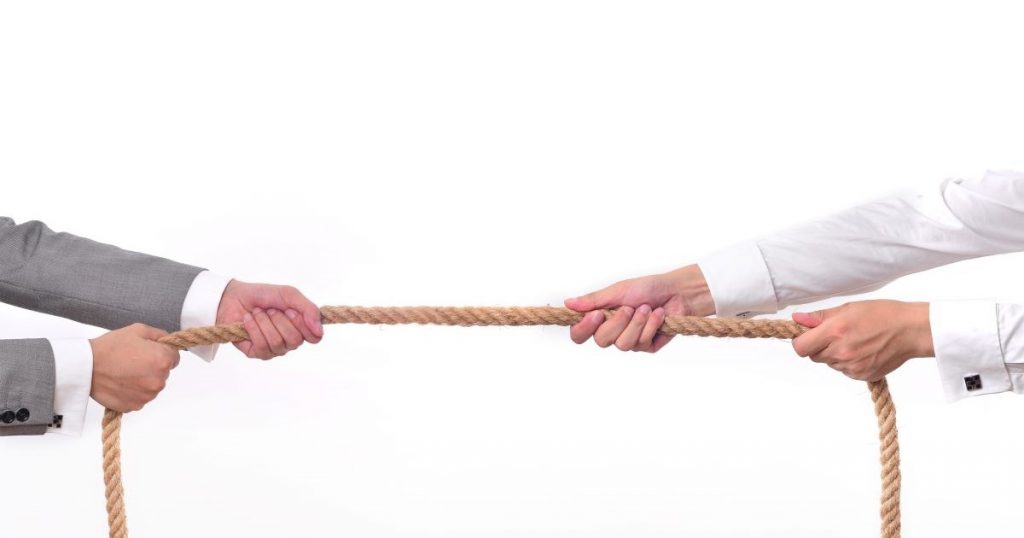 two business men pulling rope tug a war