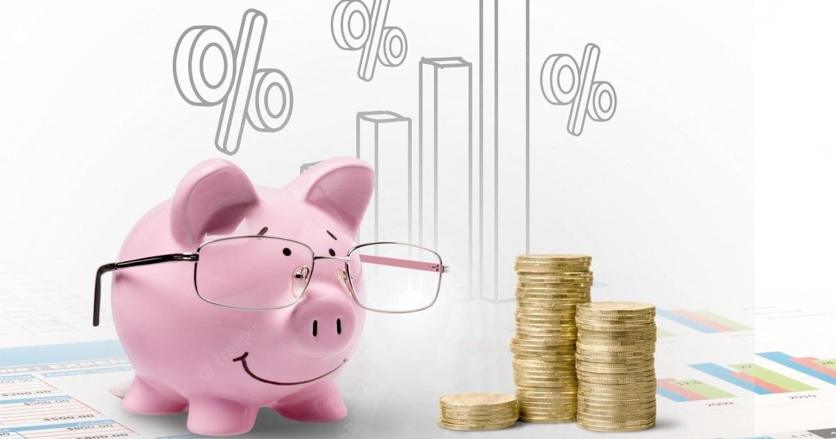 pink piggy bank with glasses coins charts figures background