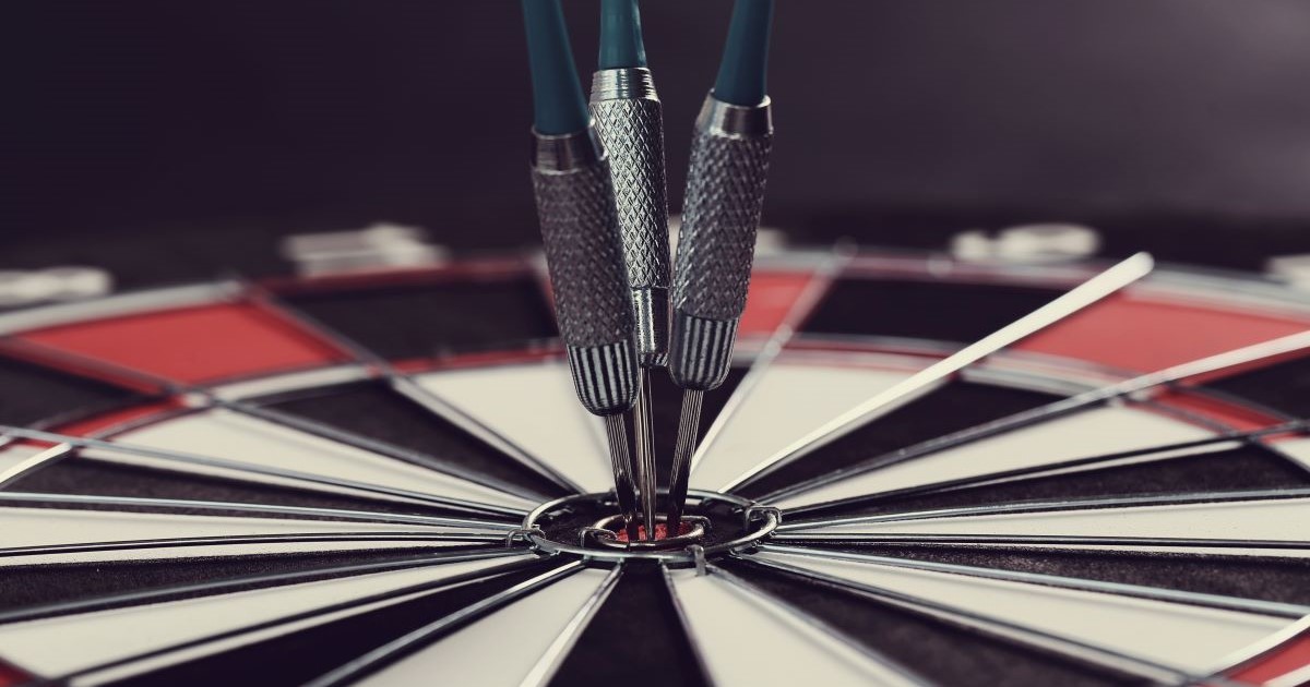 darts board with three darts in bullseye