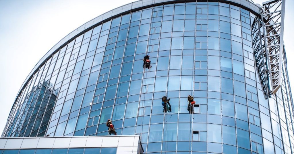 workers washing windows outside high rise office building