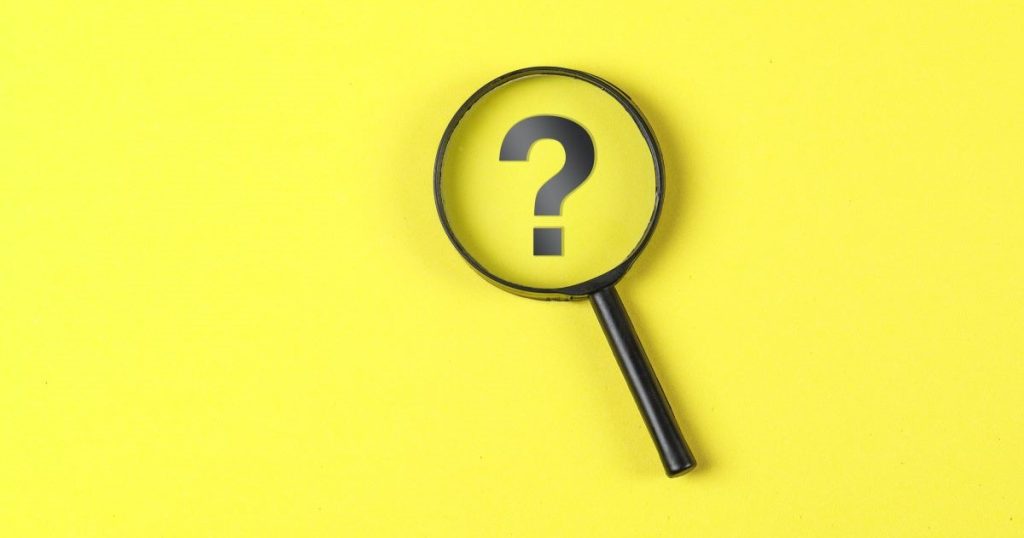 business concept with magnifying glass question mark yellow background