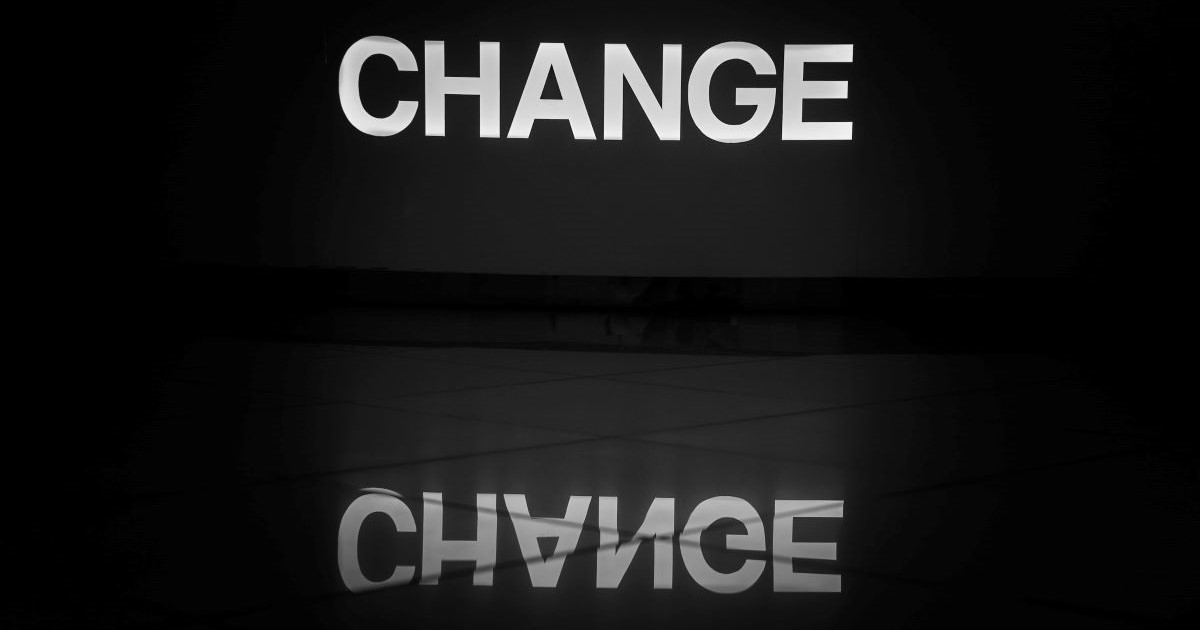 A sign with change word and reverse reflection