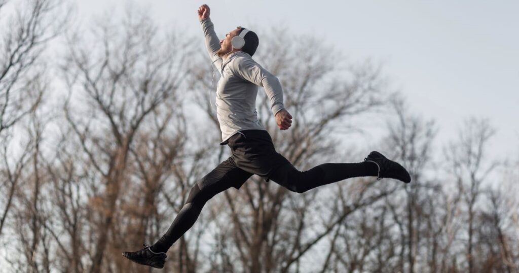 lateral view of forest with sportsman jumping in the air